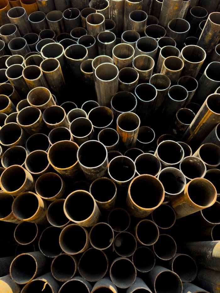 A detailed view of stacked rusty metal pipes in an industrial setting, showcasing decay and grunge.