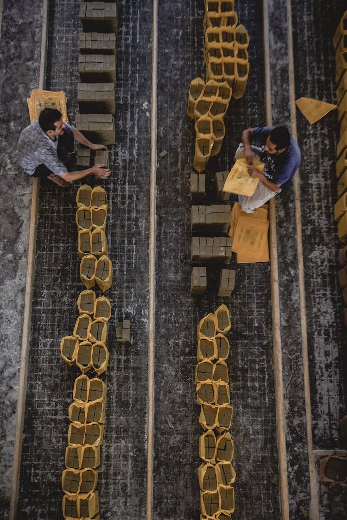 about-us-02 Aerial view of two men organizing packaging materials in an industrial setting.